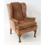An early 20thC wingback armchair with swept arms and standing on cabriole front legs. 34" wide x 34"