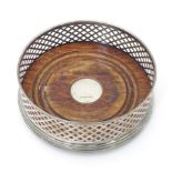 A silver bottle coaster with turned wooden base hallmarked Birmingham 2000, maker W. I. Broadway &