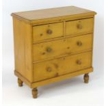 A Victorian pine chest of drawers with a moulded top above two short over two long graduated drawers