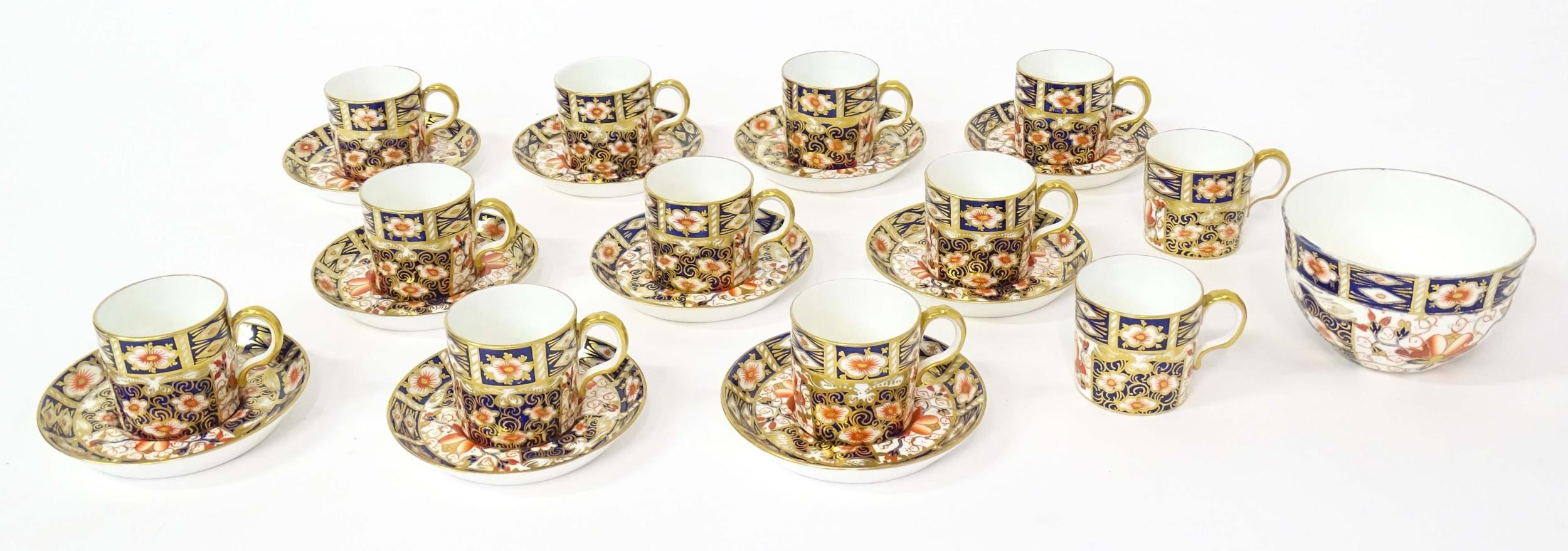 A quantity of Royal Crown Derby coffee cups, saucers, and a sugar bowl decorated in the Imari