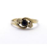 A 9ct gold ring set with central blue spinel flanked by diamonds. Ring size approx. N Please