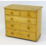 A Victorian pine chest of drawers with a moulded top above two short over three long drawers with