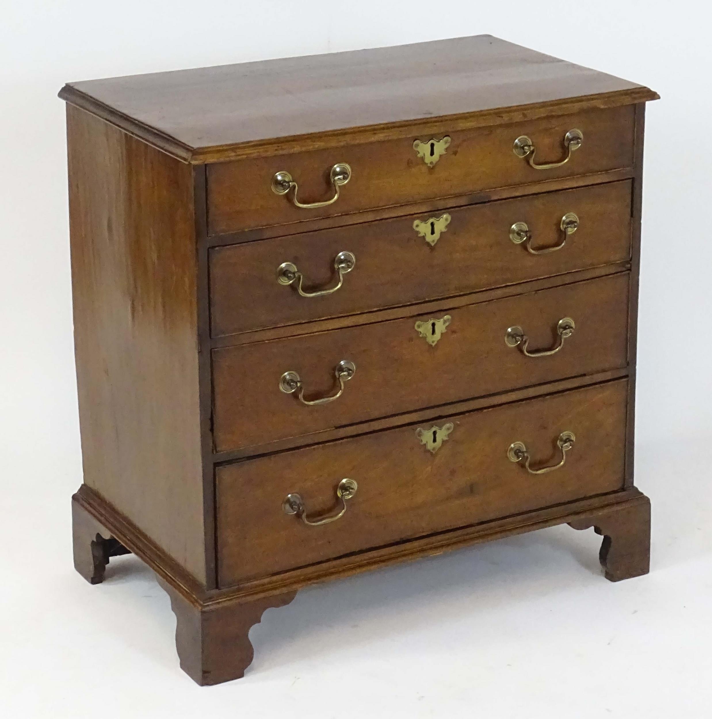 A Georgian mahogany chest of drawers with a moulded top above four long drawers with swan neck