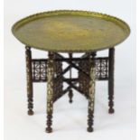An early 20thc Islamic brass top folding table, with bone and mother of pearl inlay. 27" in diameter