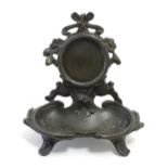 A late 19th / early 20thC cast pocket watch stand with crested ribboning, flowers and a shaped