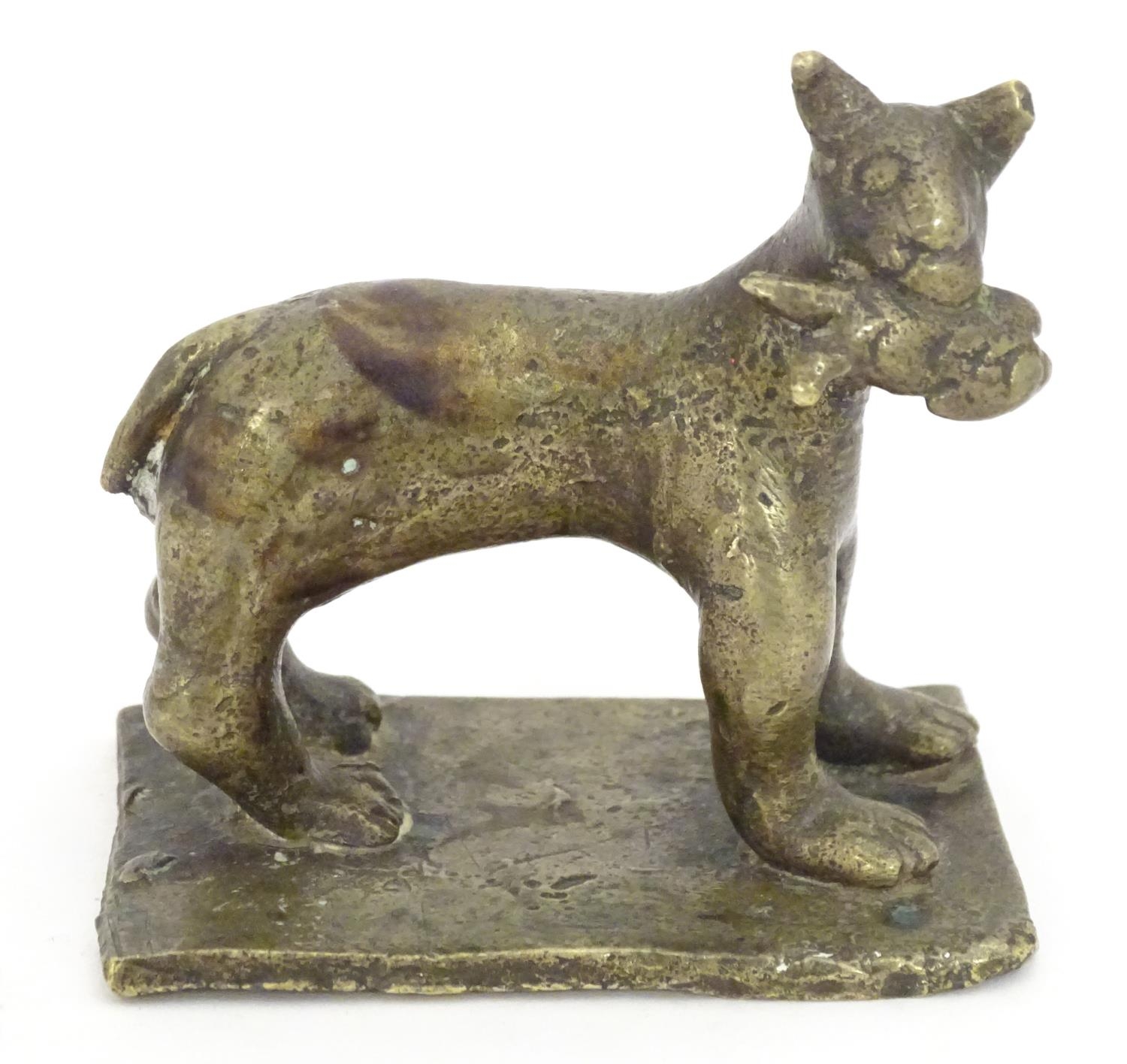 An 18th / 19th century naive bronze model of a standing cat with a fish, on a rectangular base.