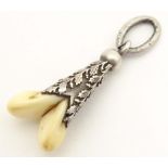 A hunting trophy pendant set with a deers tooth within a white metal mount with oak leaf and acorn