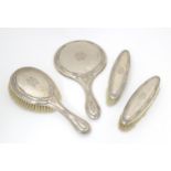 A silver dressing table set comprising hand mirror and brushes, hallmarked Birmingham 1907 & 1921,