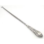 A button hook with embossed silver handle, hallmarked Birmingham 1900. Approx. 11" long Please