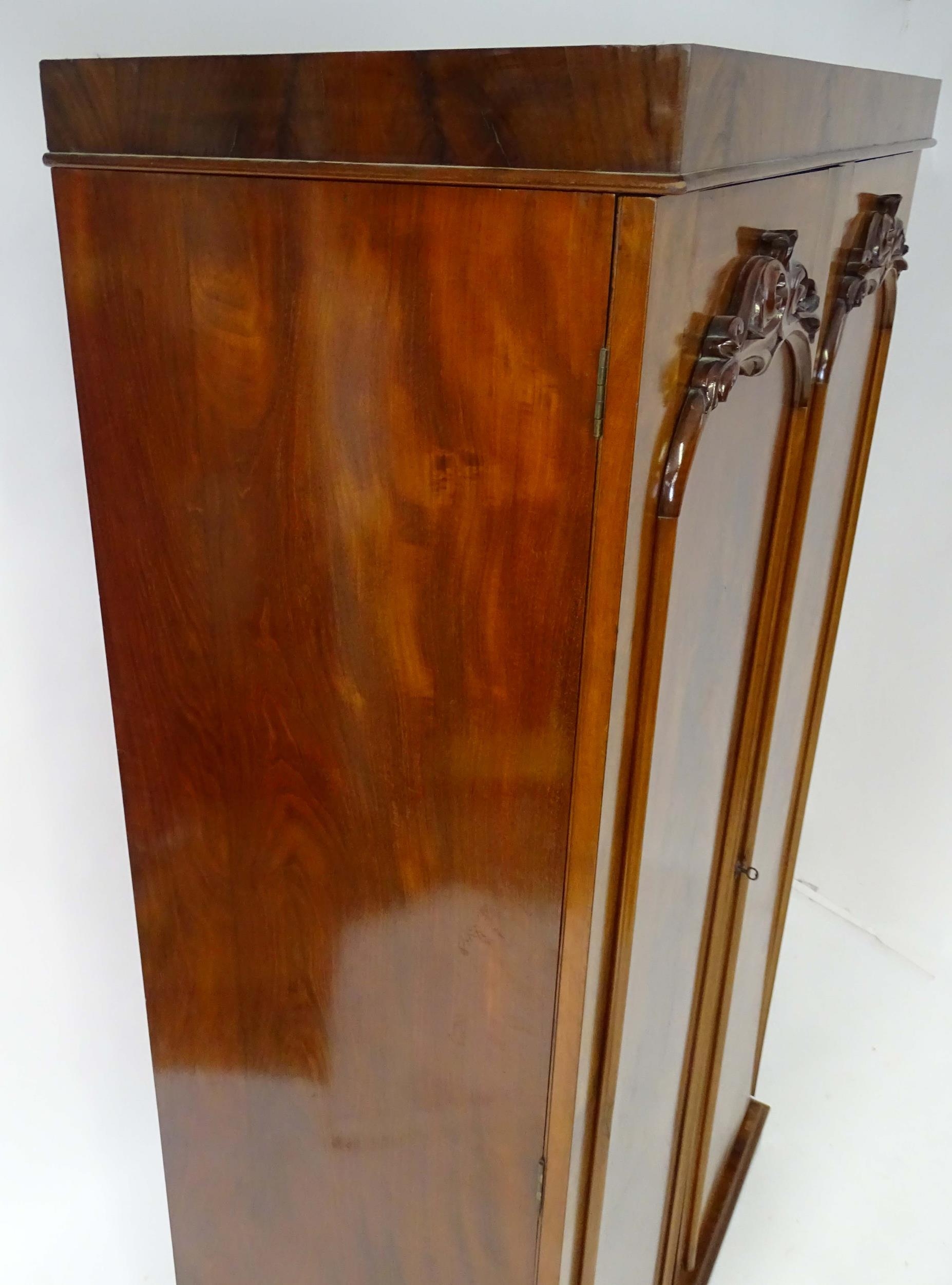 A mid 19thC mahogany double wardrobe with two panelled doors adorned with carved foliage and opening - Image 7 of 9