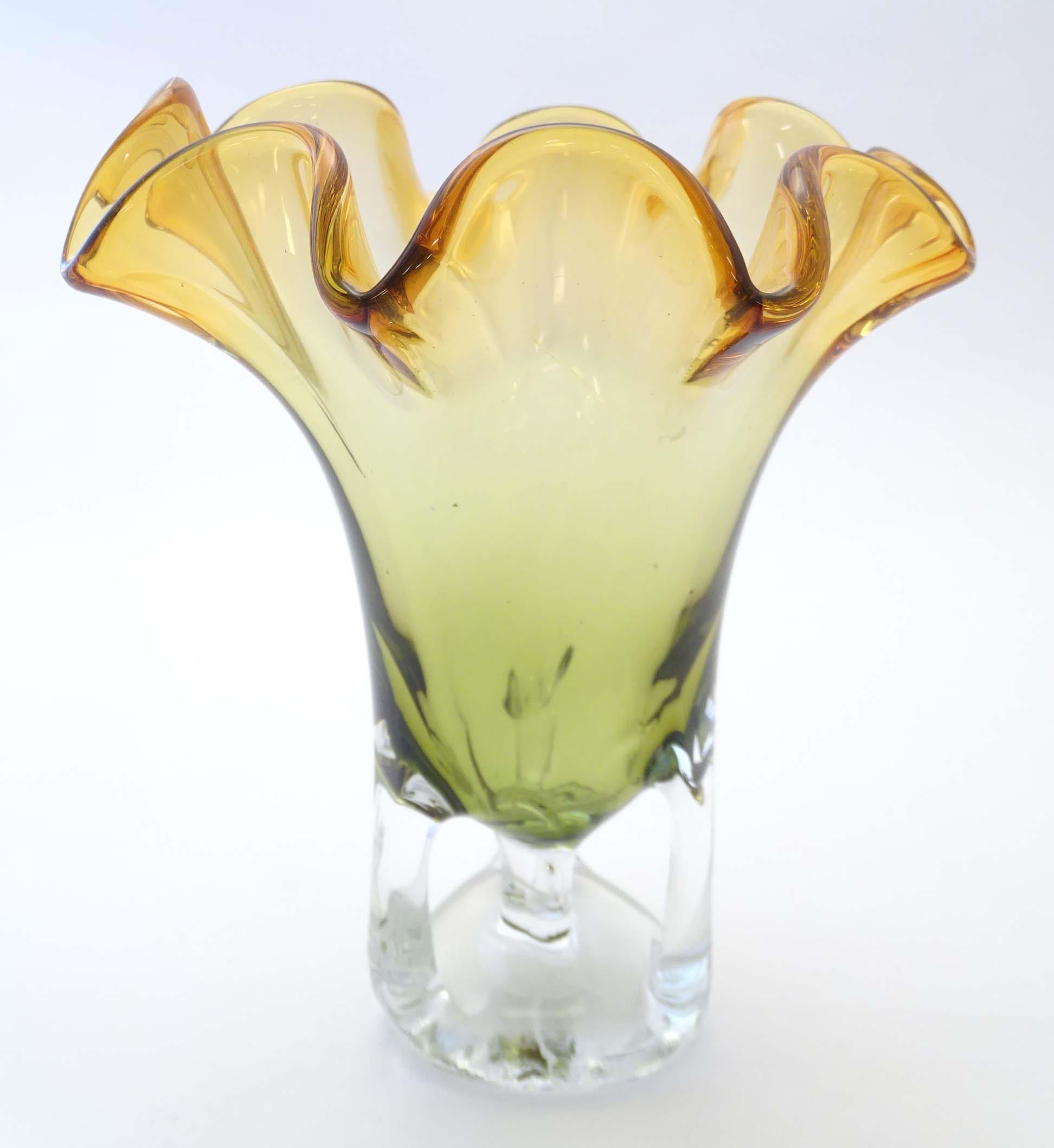 A studio glass vase with amber flared rim and body on a open clear glass base. Approx 11" high