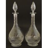 A pair of late 19thC / early 20thC glass decanters and stoppers with cut decoration. Approx 14" high