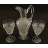 A cut glass claret jug with a pair of cut glass pedestal drinking glasses. The jug 10 1.2" high. the