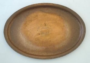 An Arts & Crafts copper tray of oval form with ship decoration to centre by Hugh Wallis. Stamped