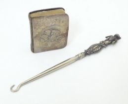 A silver button hook the handle formed as a bear hallmarked Birmingham 1909, maker Adie Lovekin Ltd.