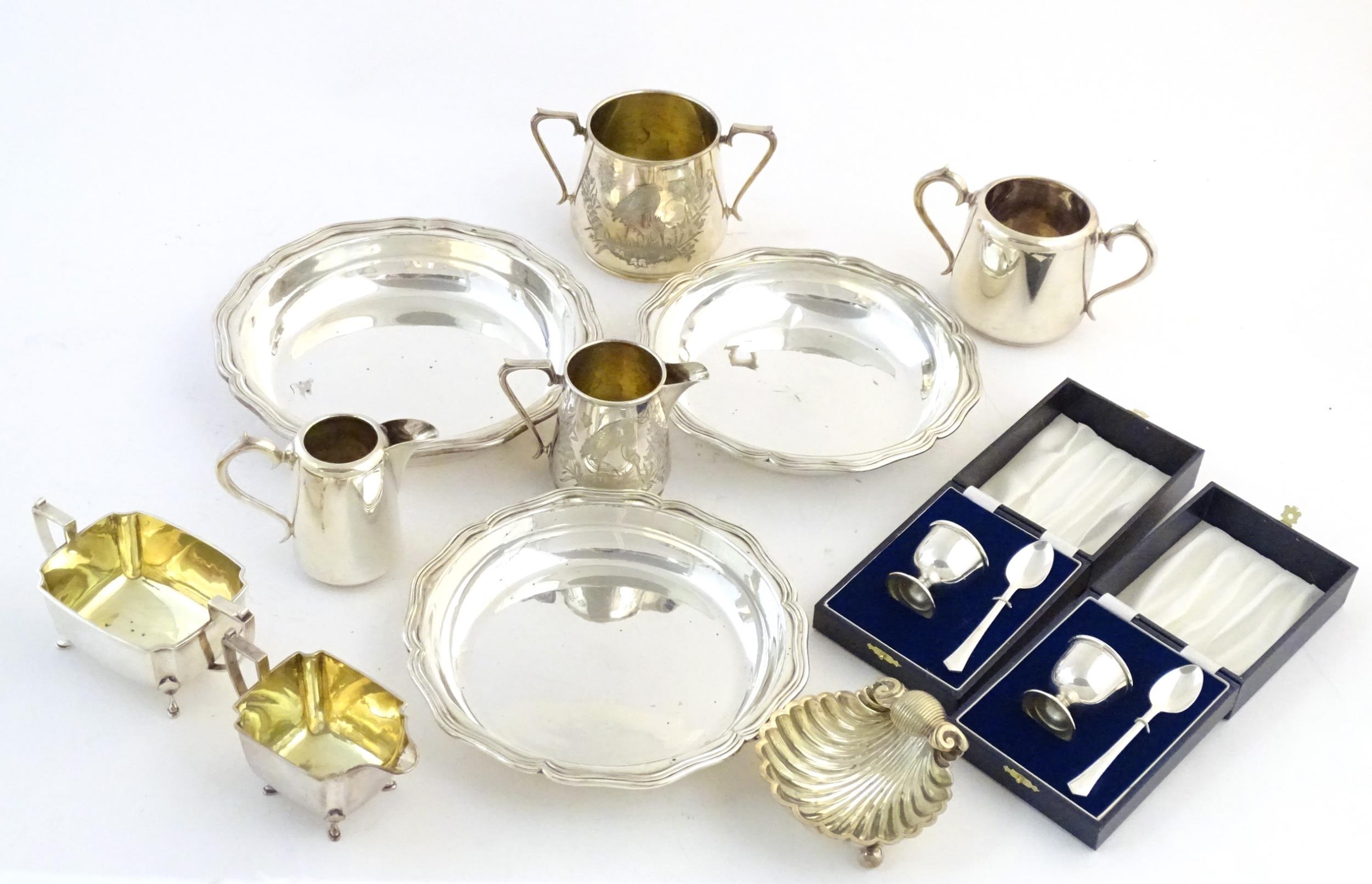 Assorted silver plated wares to include a scallop shell formed butter dish, two cased christening