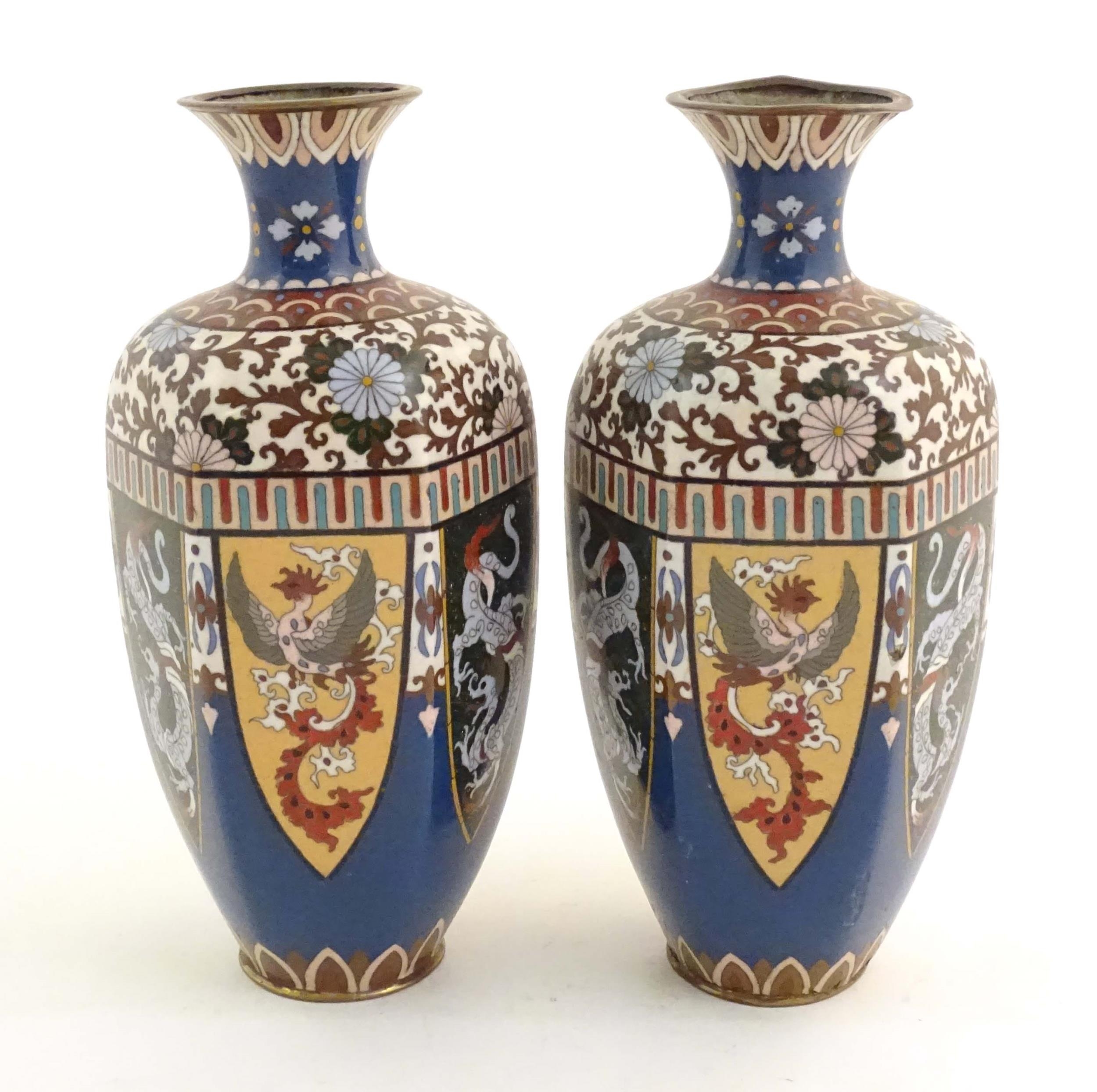 A pair of Oriental cloisonne vases decorated with panels of dragons and phoenix birds, the shoulders