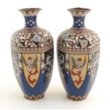 A pair of Oriental cloisonne vases decorated with panels of dragons and phoenix birds, the shoulders