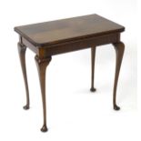 A mid / late 20thC card table with an opening and revolving top, the top having a baize playing