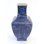 A Chinese blue and white vase of squared form decorated with stylised masks, banded detail and