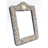 An easel back mirror with silver surround with embossed decoration, hallmarked Birmingham 1908,