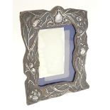 An Art Nouveau photograph frame with silver surround decorated with embossed Art Nouveau floral