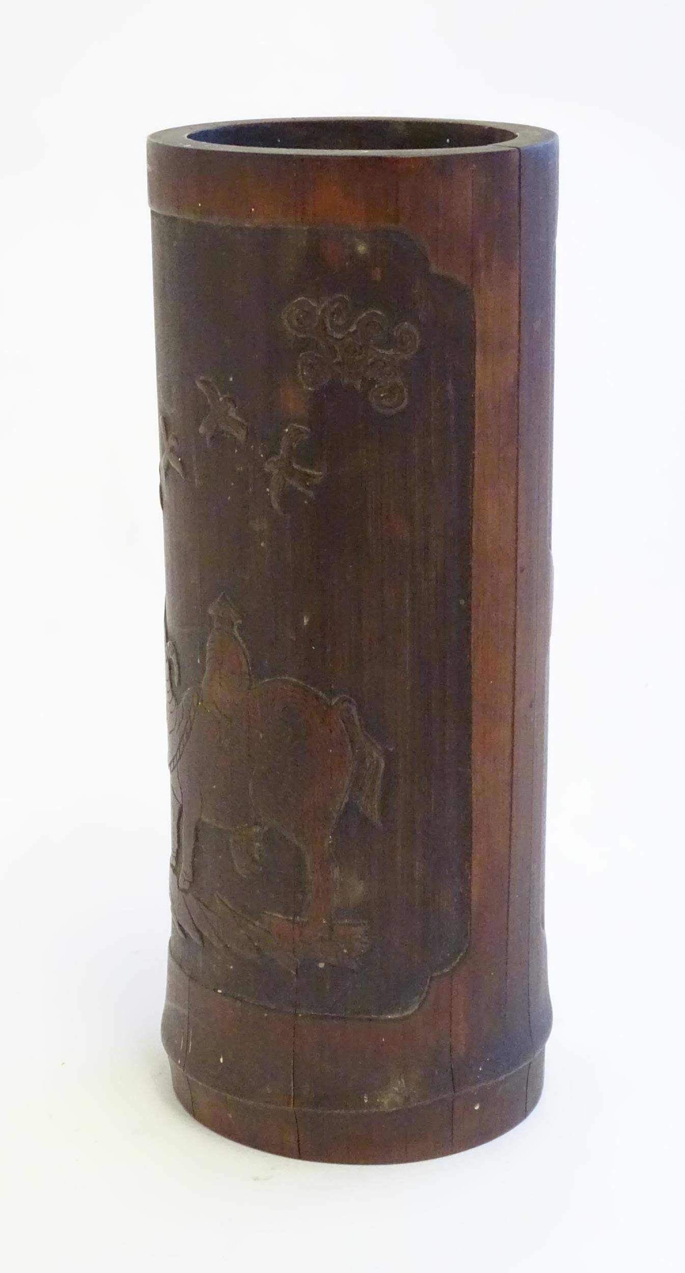 An Oriental carved bamboo vase depicting a figure on a water buffalo with birds. Approx. 10" high