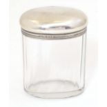 A glass dressing table jar of oval form with facet detail and silver top hallmarked London 1921
