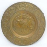 A large 20thC Indian brass charger with embossed decoration depicting a river landscape scene with