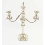 A silver plate table candelabra with two scrolling branches and acanthus scroll detail. Approx 21"
