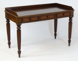 A Regency period mahogany dressing table with a shaped upstand above three shaped drawers and raised