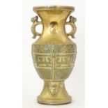 An Oriental cast brass vase of baluster form with twin foo dog handles, the body decorated with