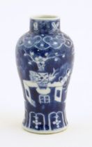 A small Chinese blue and white vase decorated with flowers in a vase and banded borders. Character