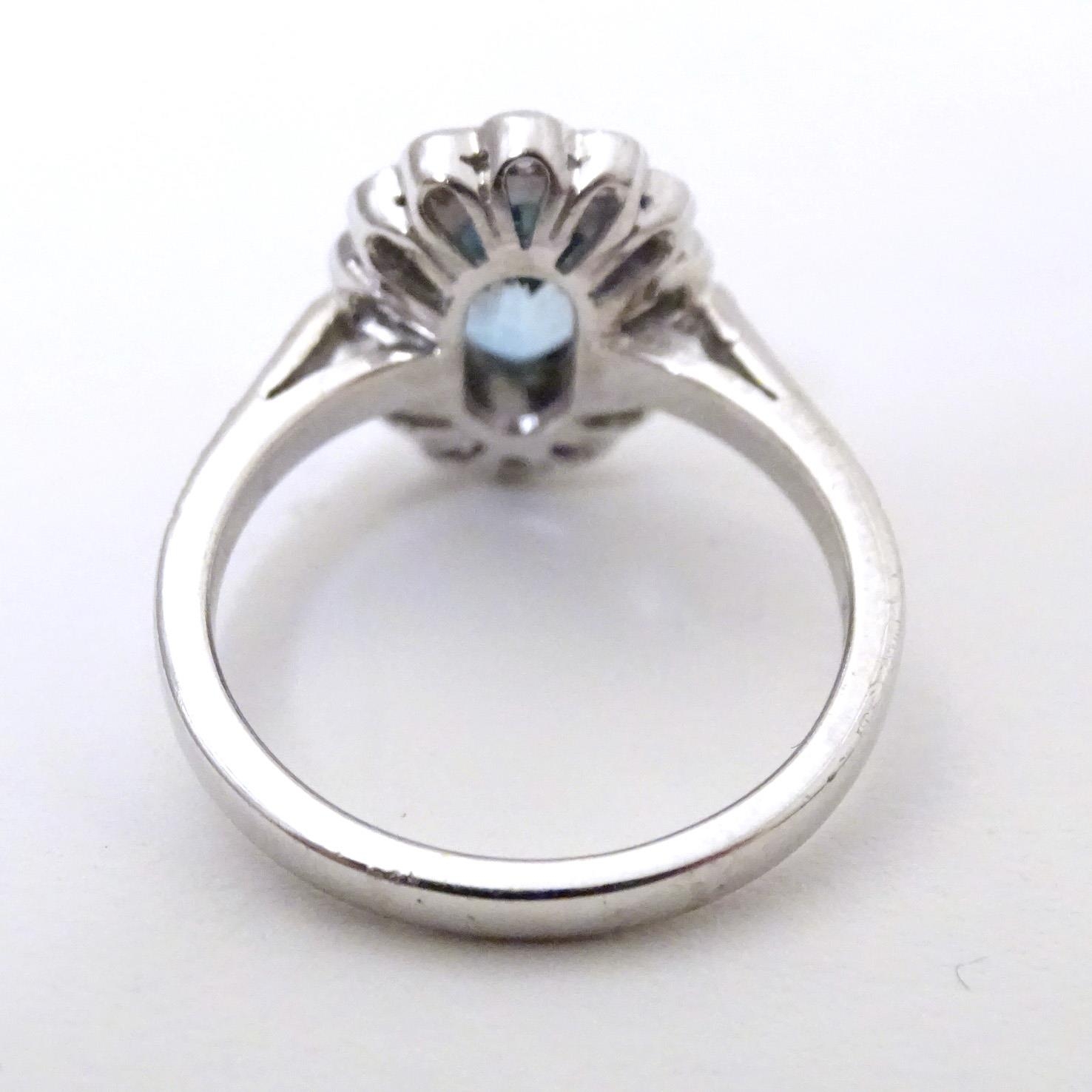 A 9ct white gold ring set with aquamarine coloured oval stone to centre bordered by diamonds with - Image 5 of 5