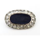 A 19thC brooch of locket form bordered by paste stones. Approx. 1 1/2" wide Please Note - we do