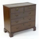 An 18thC oak chest of drawers with a moulded top above two short over three long graduated drawers