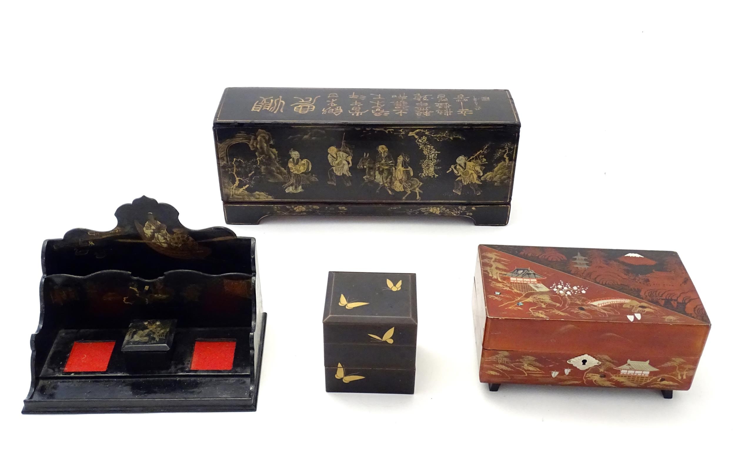 Four Oriental lacquered items comprising a desk tidy / organiser with shaped back decorated with a