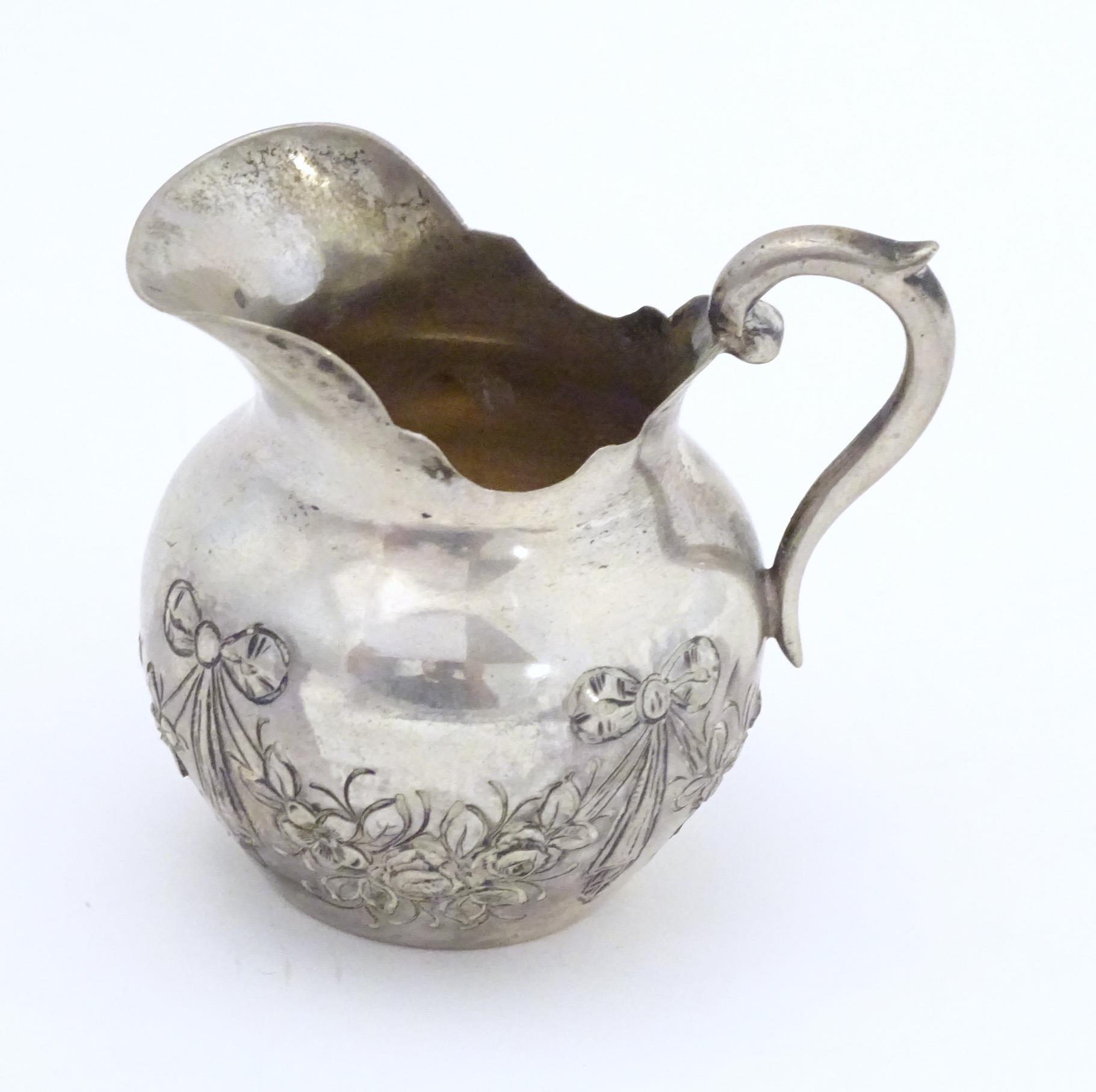 A small Continental .800 silver cream jug with ribbon and swag decoration. Marked under possibly - Image 3 of 5