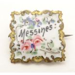 A gilt metal brooch of square form with enamel floral decoration and titled Messines. Approx. 1"