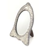 An easel back mirror with white metal surround with embossed decoration. Approx. 12 1/2" high