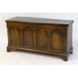 A late 17thC / early 18thC oak coffer with a moulded lid above a four panel arched front and