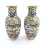 A pair of Japanese vases of baluster form with panelled decoration depicting ladies by a river
