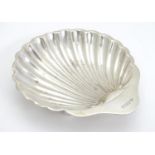 A silver scallop-shaped dish raised on three bun feet. Hallmarked Sheffield 1910 maker Harrison