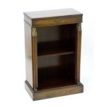 An early 20thC mahogany bookcase with a reeded edge above applied gilt metal work flanked by