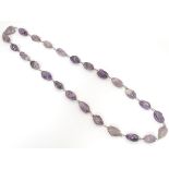 A white metal and amethyst necklace. Approx. 28" long Please Note - we do not make reference to