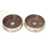 A pair of silver coaster with turned wooden bases. Hallmarked London 1987 maker Payne & Son Approx