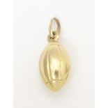 A 9ct gold and gilt metal novelty pendant / charm formed as a rugby ball. Approx. 1" long Please