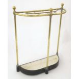 A Victorian brass and cast iron stick stand, of demi lune form, the top with ten divisions supported