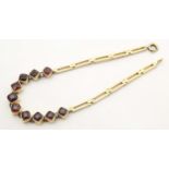 A yellow metal bracelet set with 10 garnets. Approx 7 1/2" long Please Note - we do not make