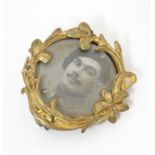 An early 20thC gilt metal locket brooch with image to centre depicting a soldier. Approx. 1" wide